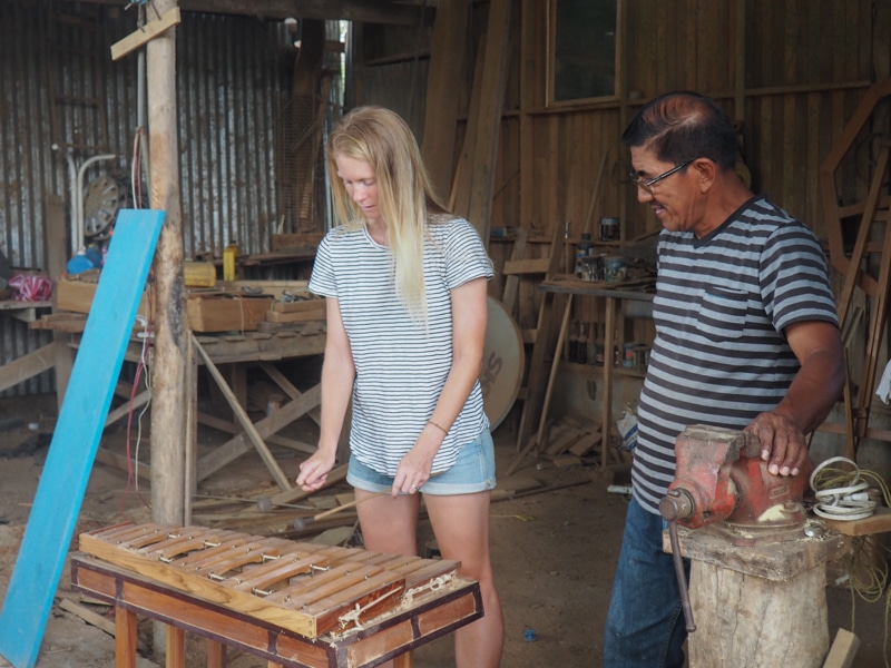 Ezequiel showing Project Manager, Laura how to play the instrument he made.