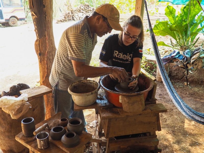 Teaching pottery to volunteer, Sophia.