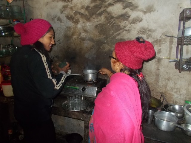 In-country volunteer, Hima, makes tea for her host family