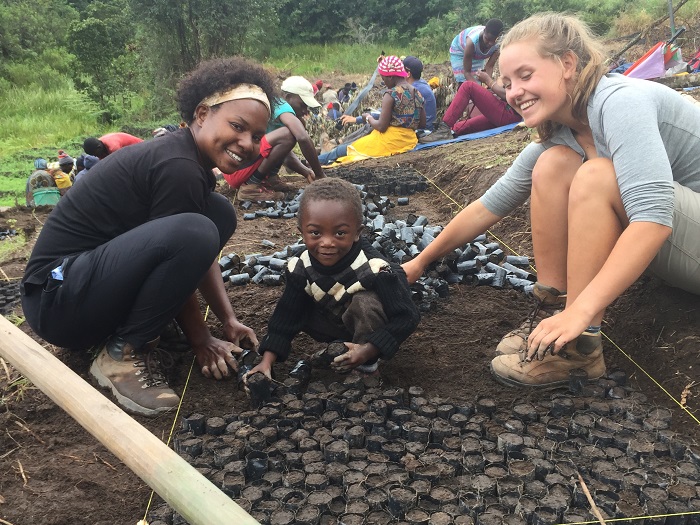 Victoria and Anne working with a young helper on the project site in Ihanu