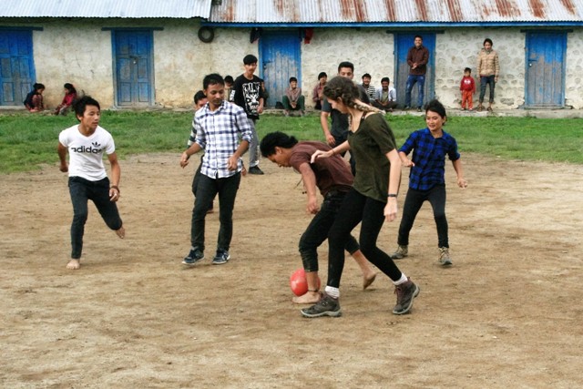 Volunteers and youths playing volleyball