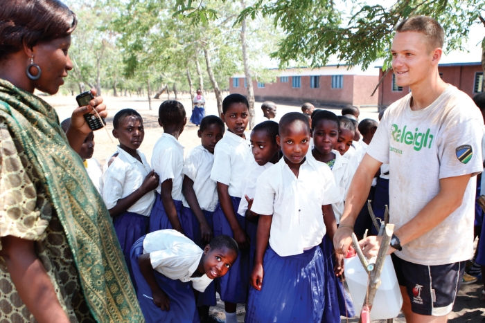 A volunteer demonstrates a tippy tap at a school in Tanzania