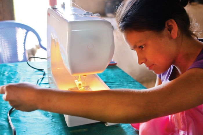 Ruth Carolina working at her sewing machine