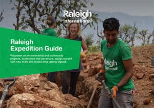 A Ralegih expedition guide with people in the local community helping build a sewage system