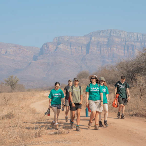 Venturers walking to project with Drakensburg in background