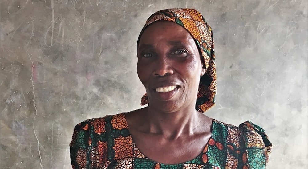 a local woman in a colorful dress smiling for the camera