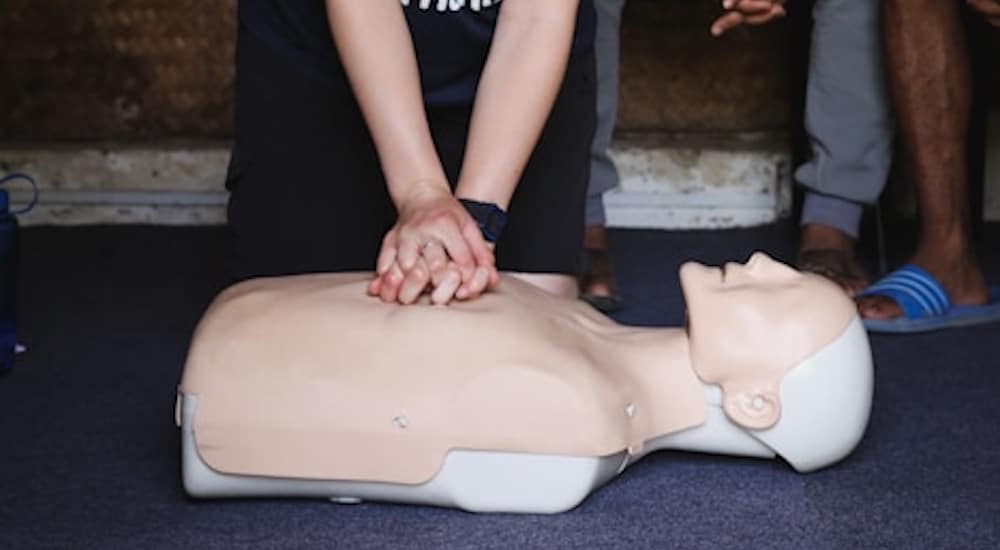 a woman doing a Cardiopulmonary resuscitation procedure to a mannequin