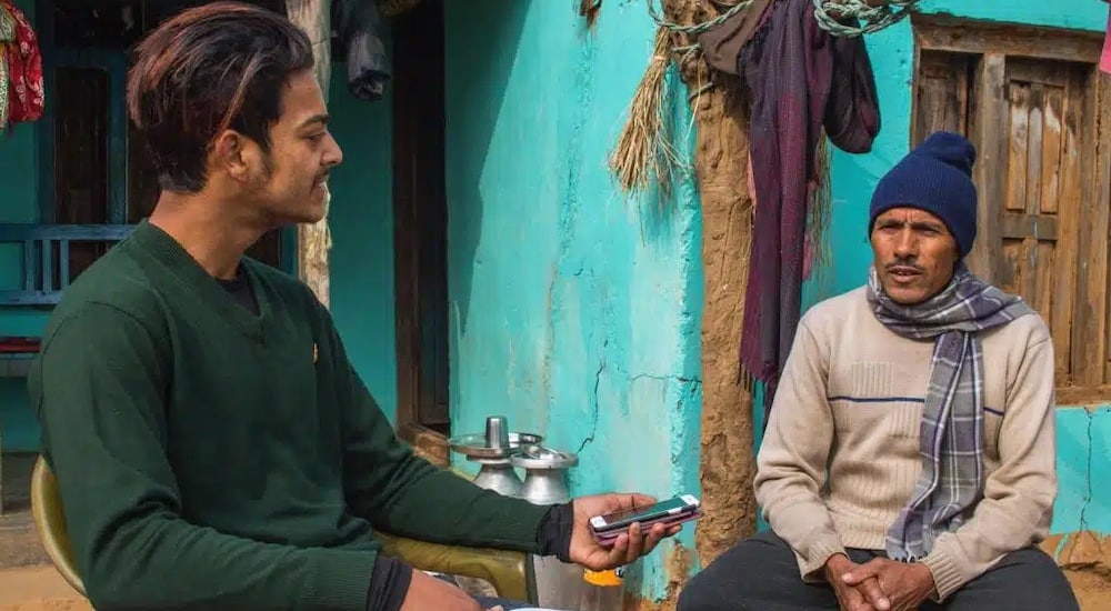a volunteer interviewing a local man