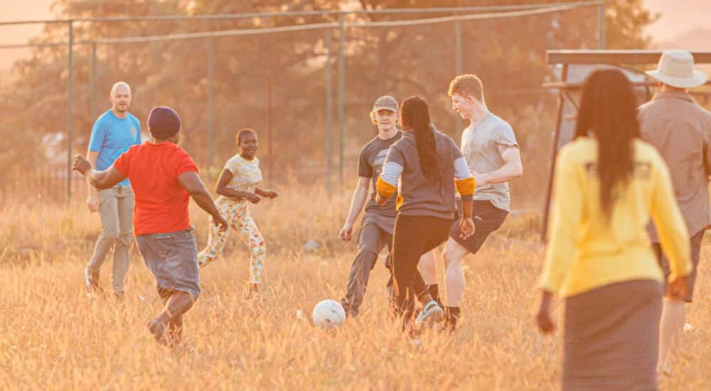 volunteers and locals playing football in the field