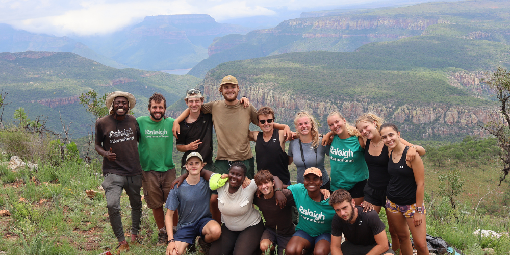 Venturers posed in front of mountain valley view